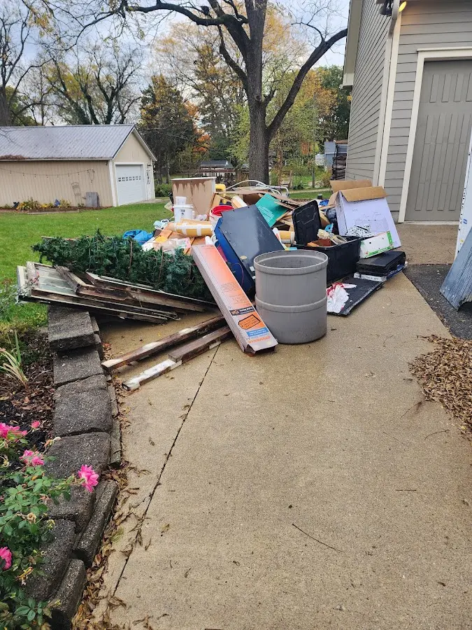 Dumpster being loaded with debris for 12 Yard Dumpster Rental in Lawrence